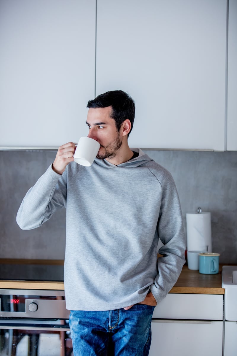 young-man-with-cup-of-coffee-staying-at-kitchen-at-2022-01-12-05-27-07-utc