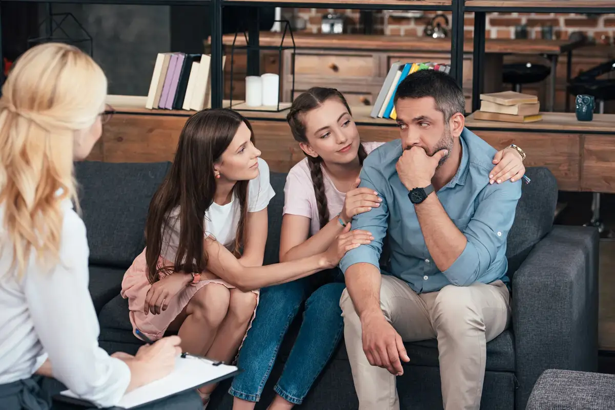 family cheering man at therapy