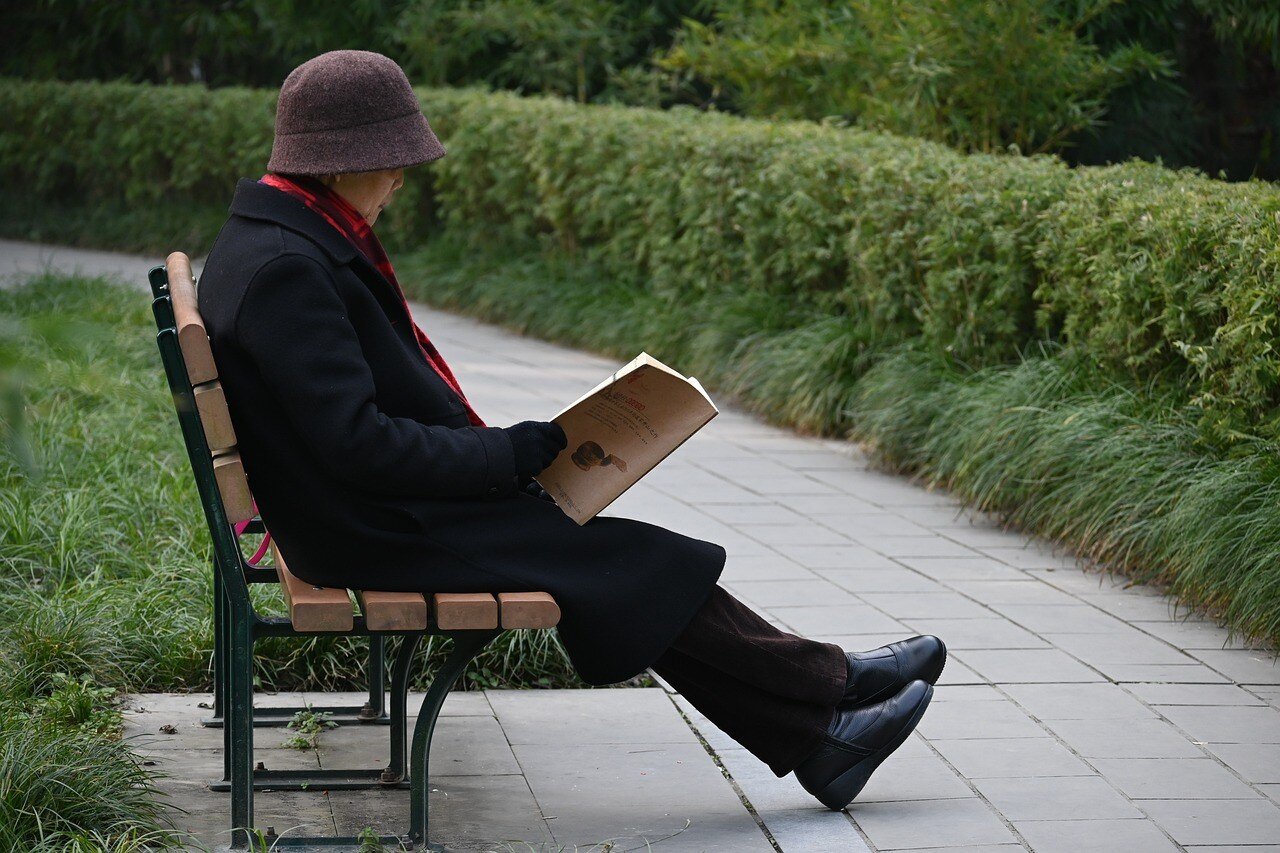 an old person with depression sits on a bench