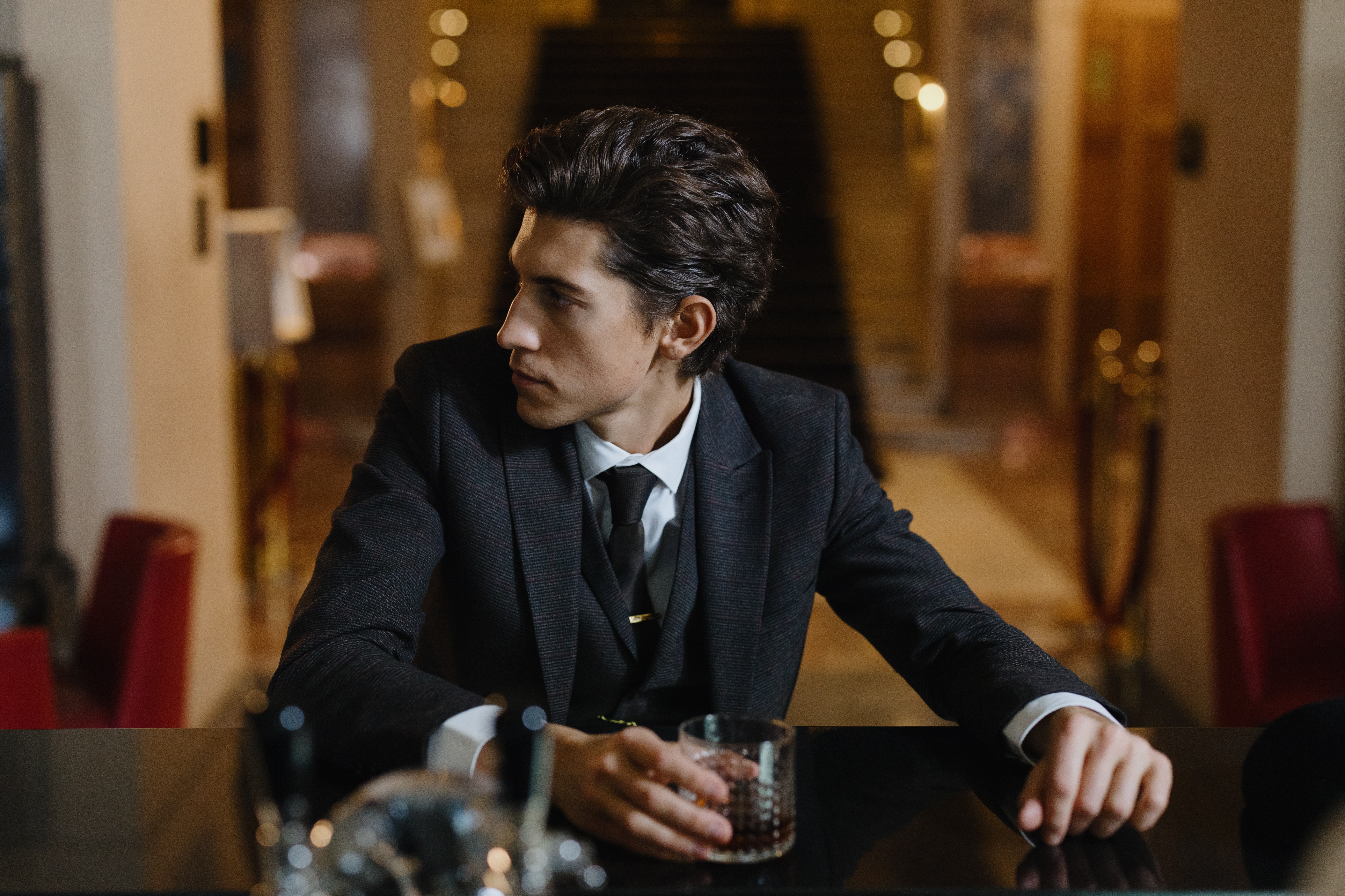 man in suit drinking and thinking