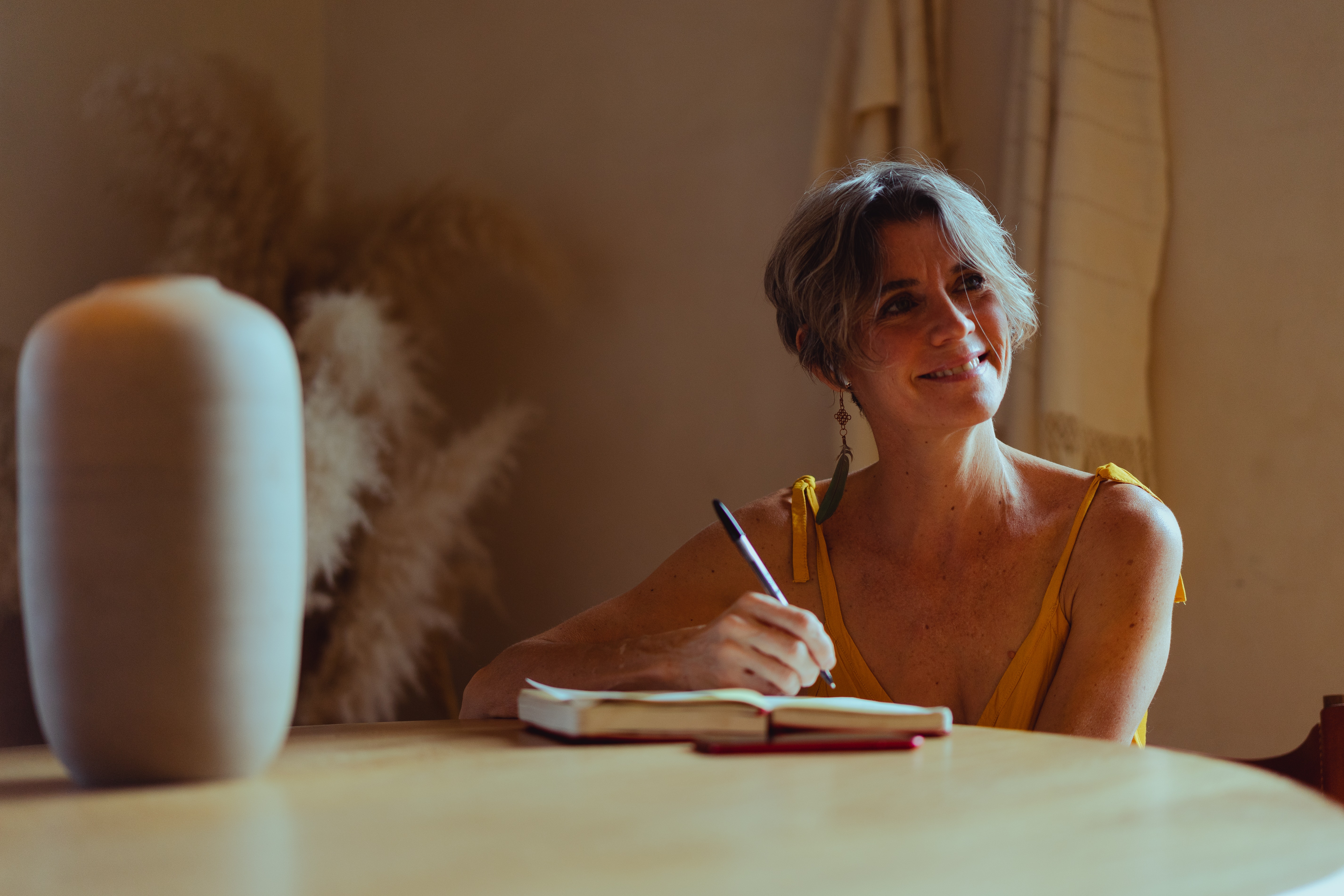 Williamsburg Therapy Group woman sitting at table smiling and journaling