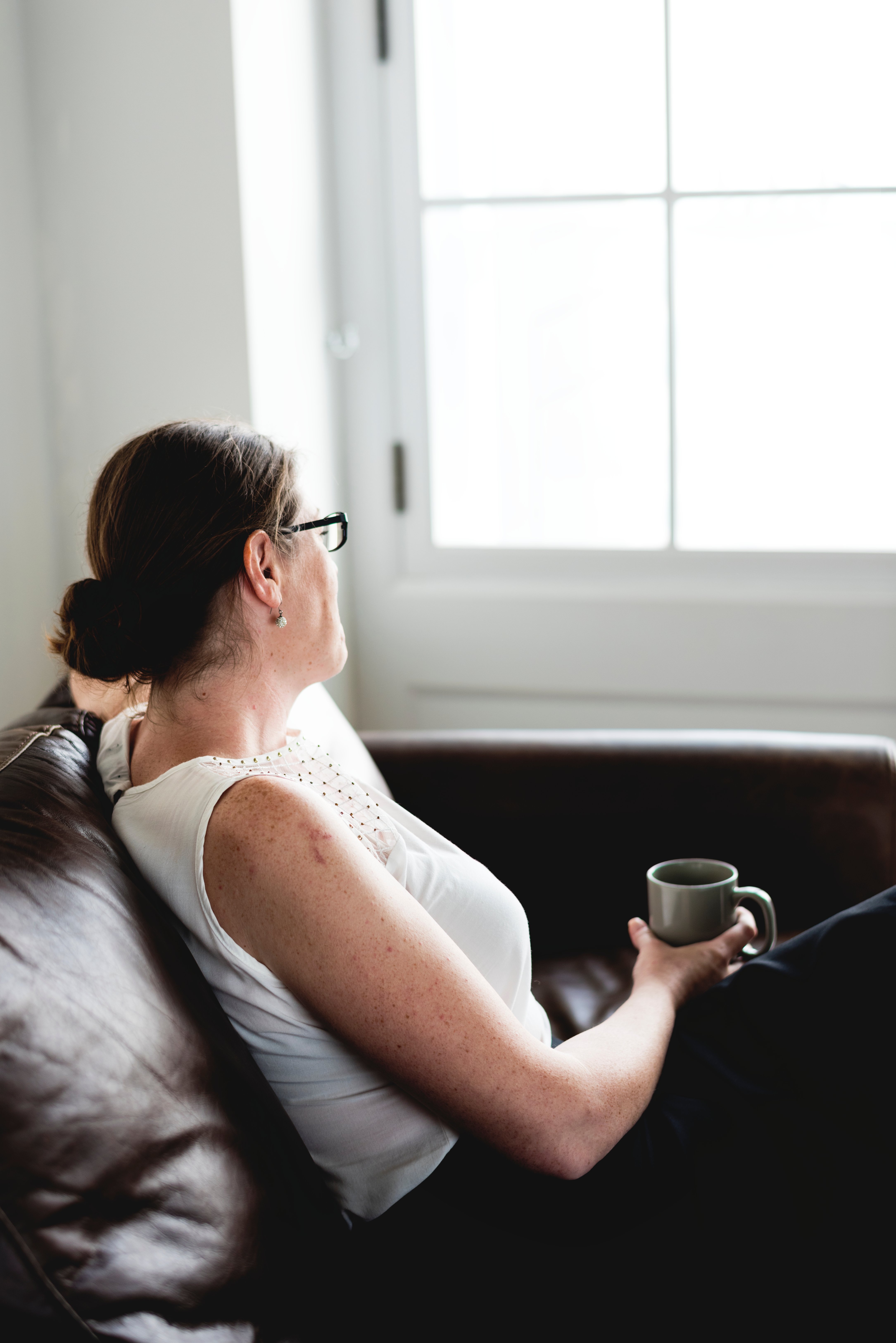 woman-sipping-a-drink-sitting-on-a-counch-2022-12-15-23-12-06-utc